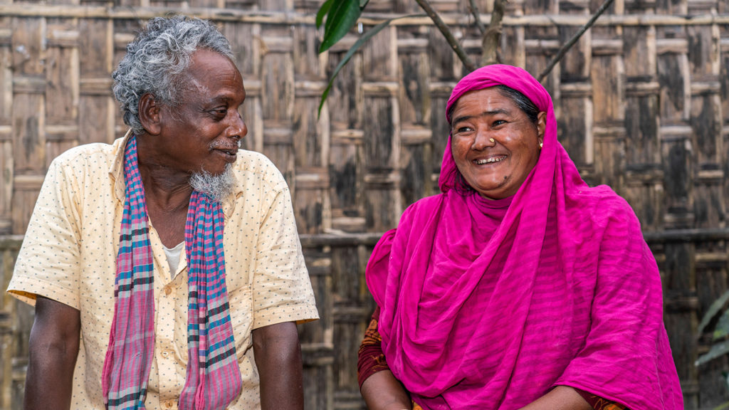 A man looking at his wife who is laughing.