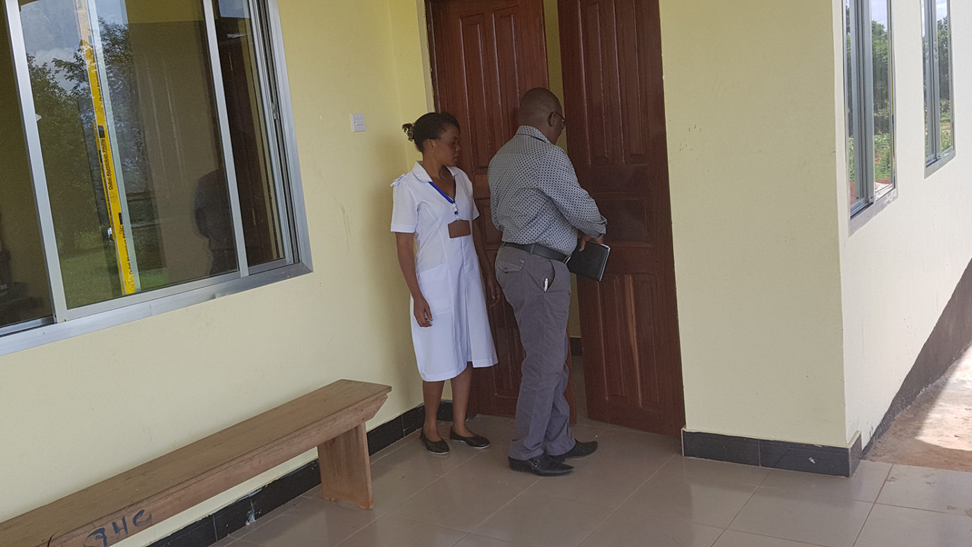 A doctor and a nurse stand outside the clinic.