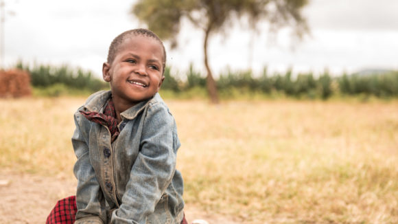 A little boy smiling outside