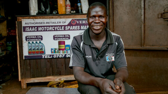 Isaac sits outside his mechanics.