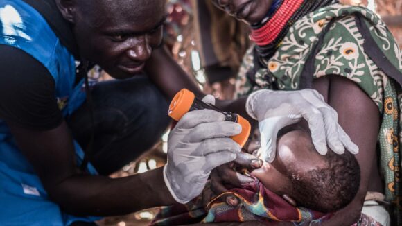 A volunteer inspects a baby's eyes for signs of trachoma.