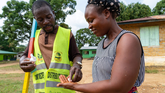 A community volunteer distributed treatment to protect against neglected tropical diseases to a woman.