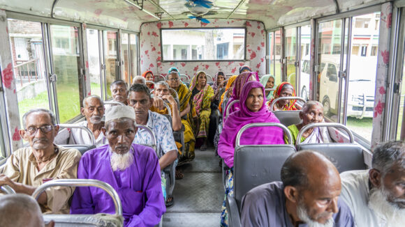 Inside of a bus with many older people sitting.
