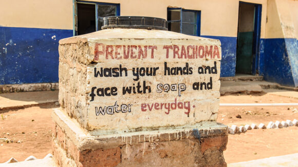 A sign telling people to wash their hands and face with soap to prevent trachoma.