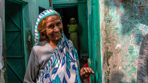 A smiling women stands in a doorway.