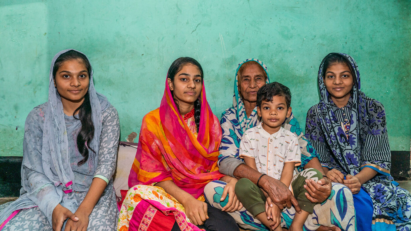 A grandmother sits with four of her grandchildren.