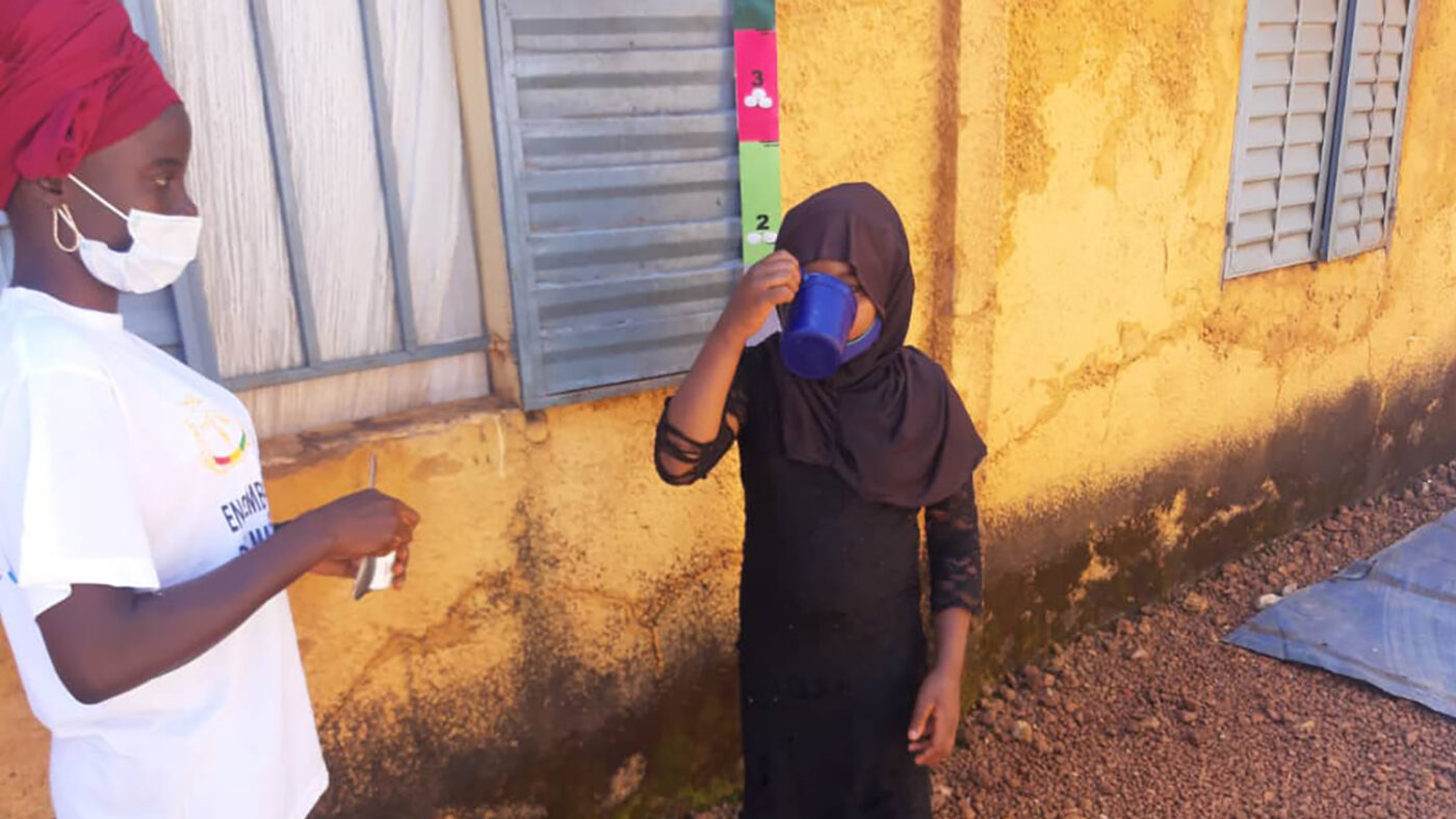 A young girl takes some medication.