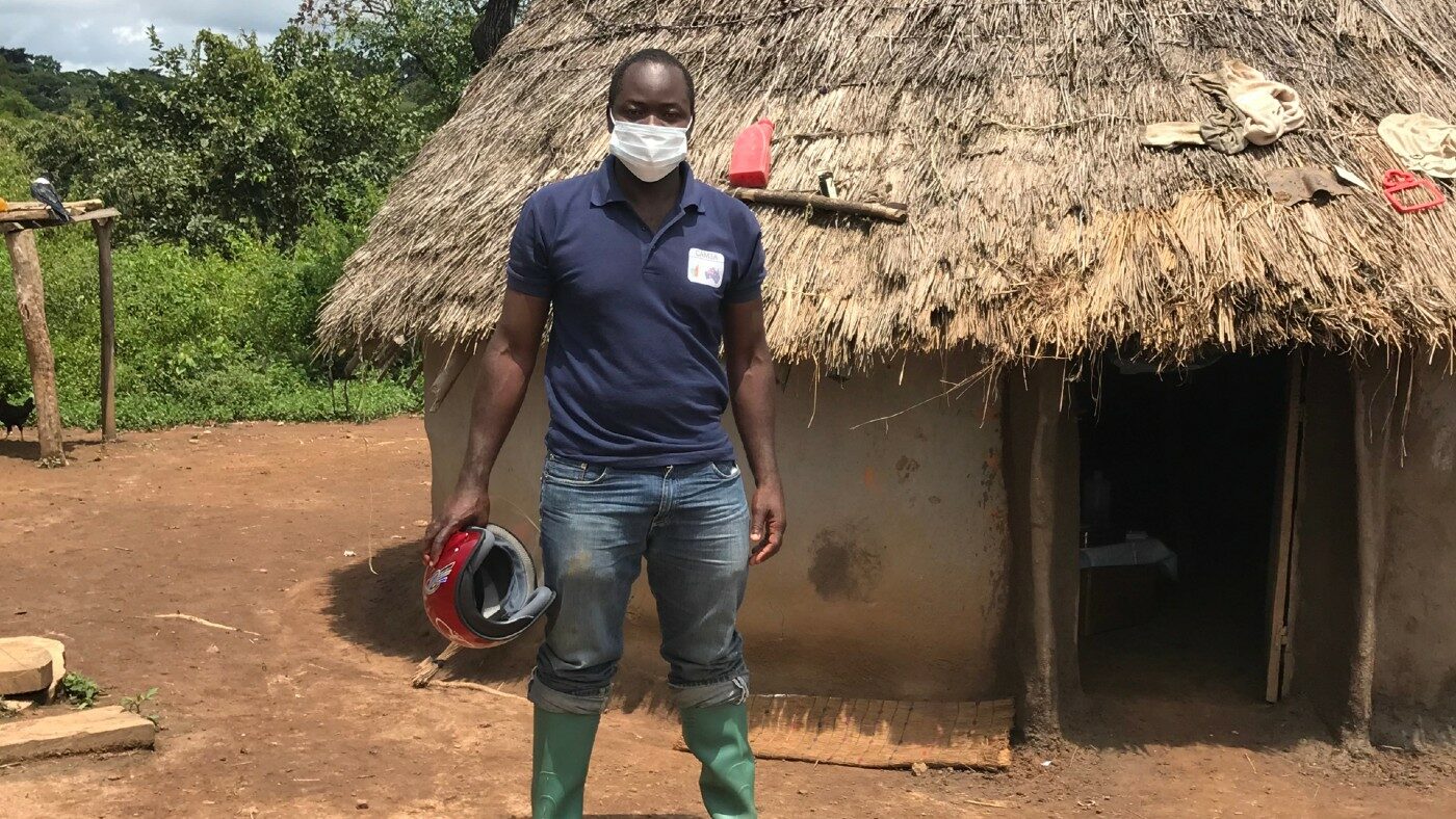 A man stands outside a nomadic hut.