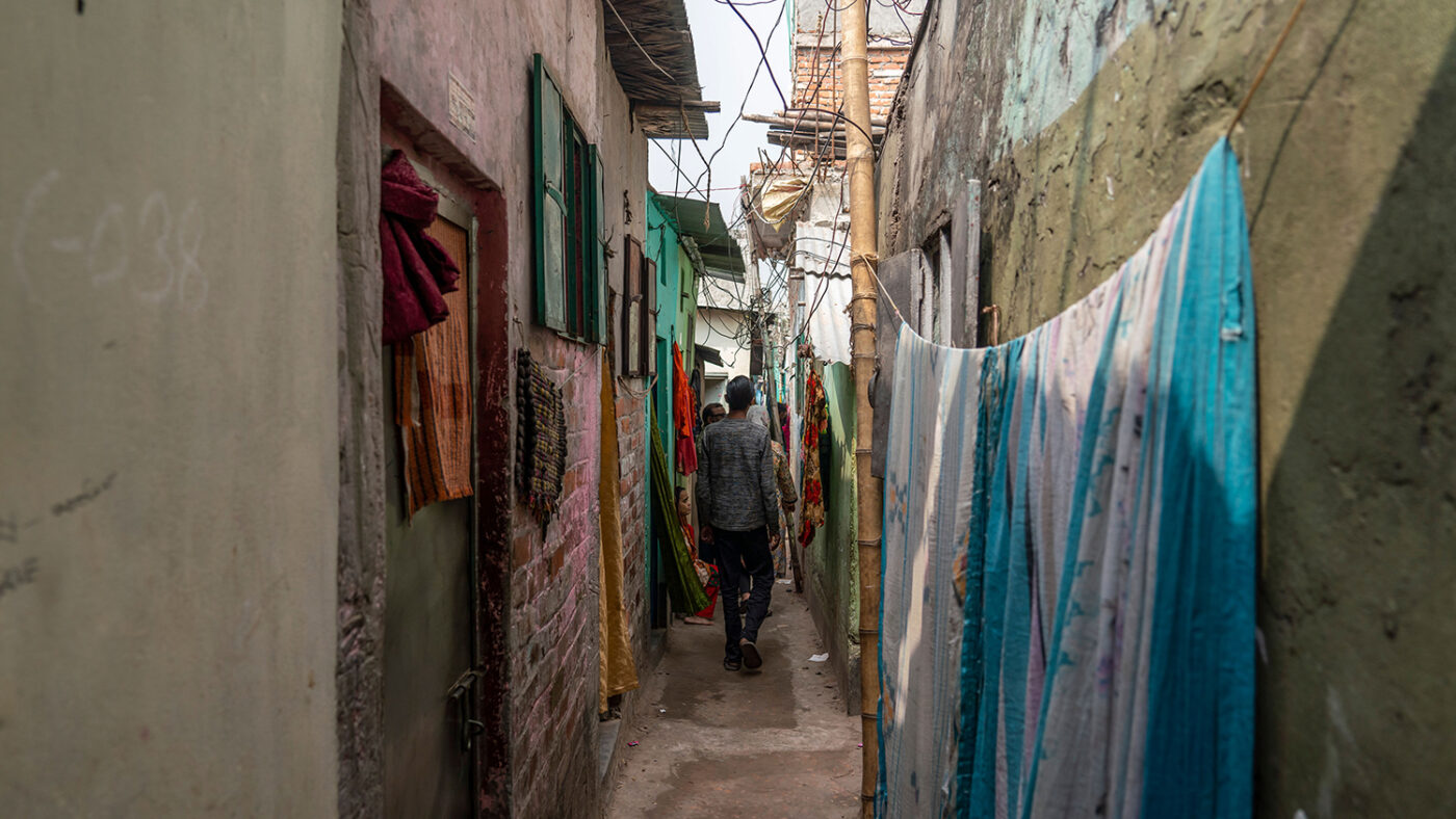 A slim walkway through an informal urban settlement.
