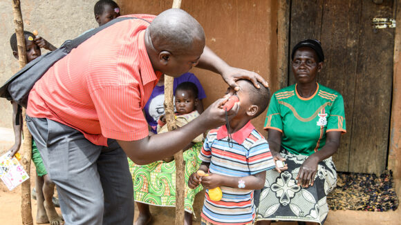 Man examining a child's eye.