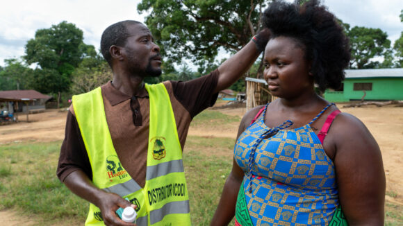 A community volunteer measures Jumah's height.