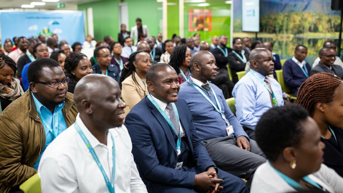A group of people sit in a room at a conference.