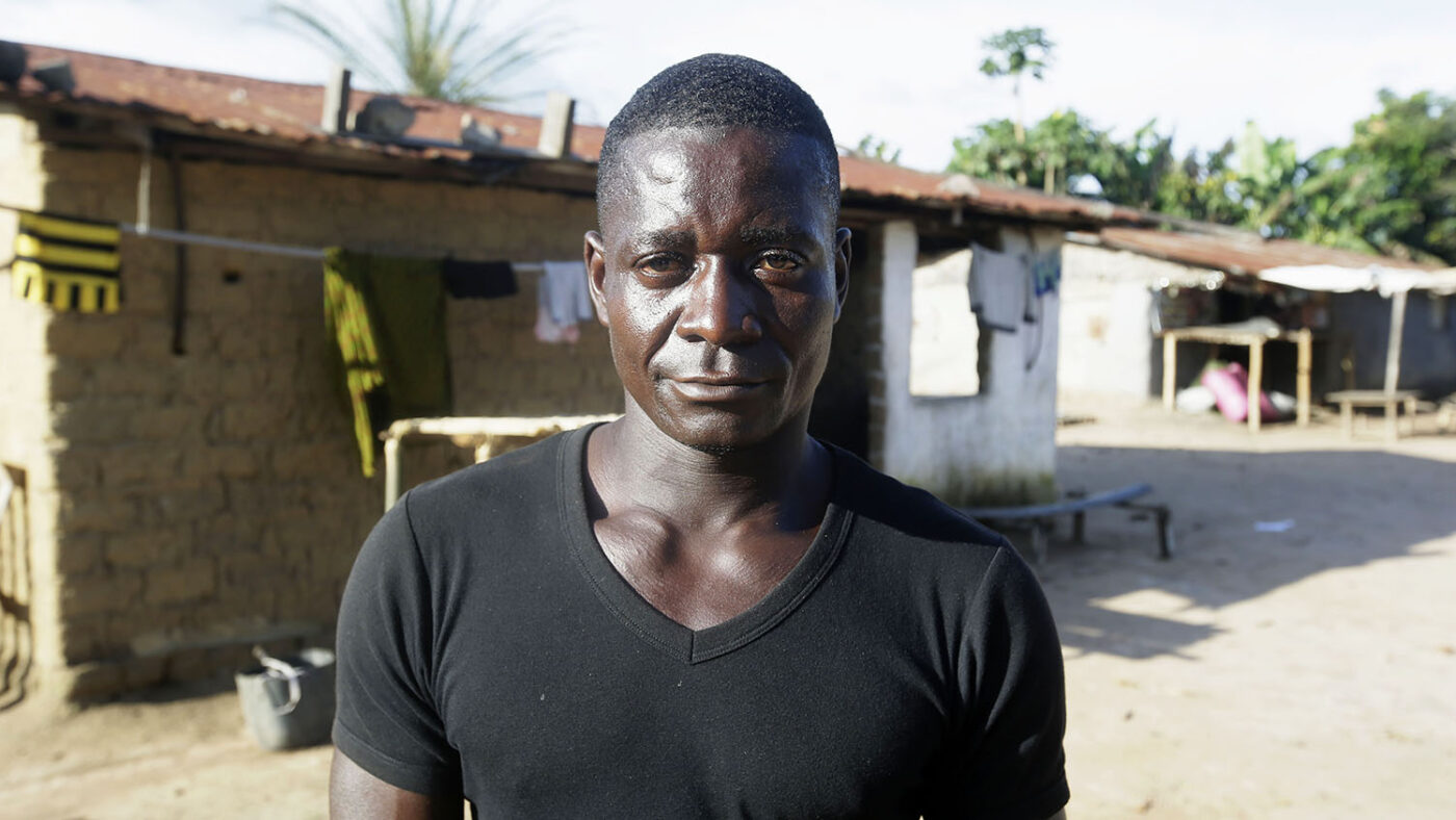 A man stands for a portrait outside.