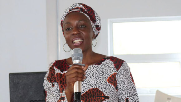 A woman holding a microphone giving a presentation.