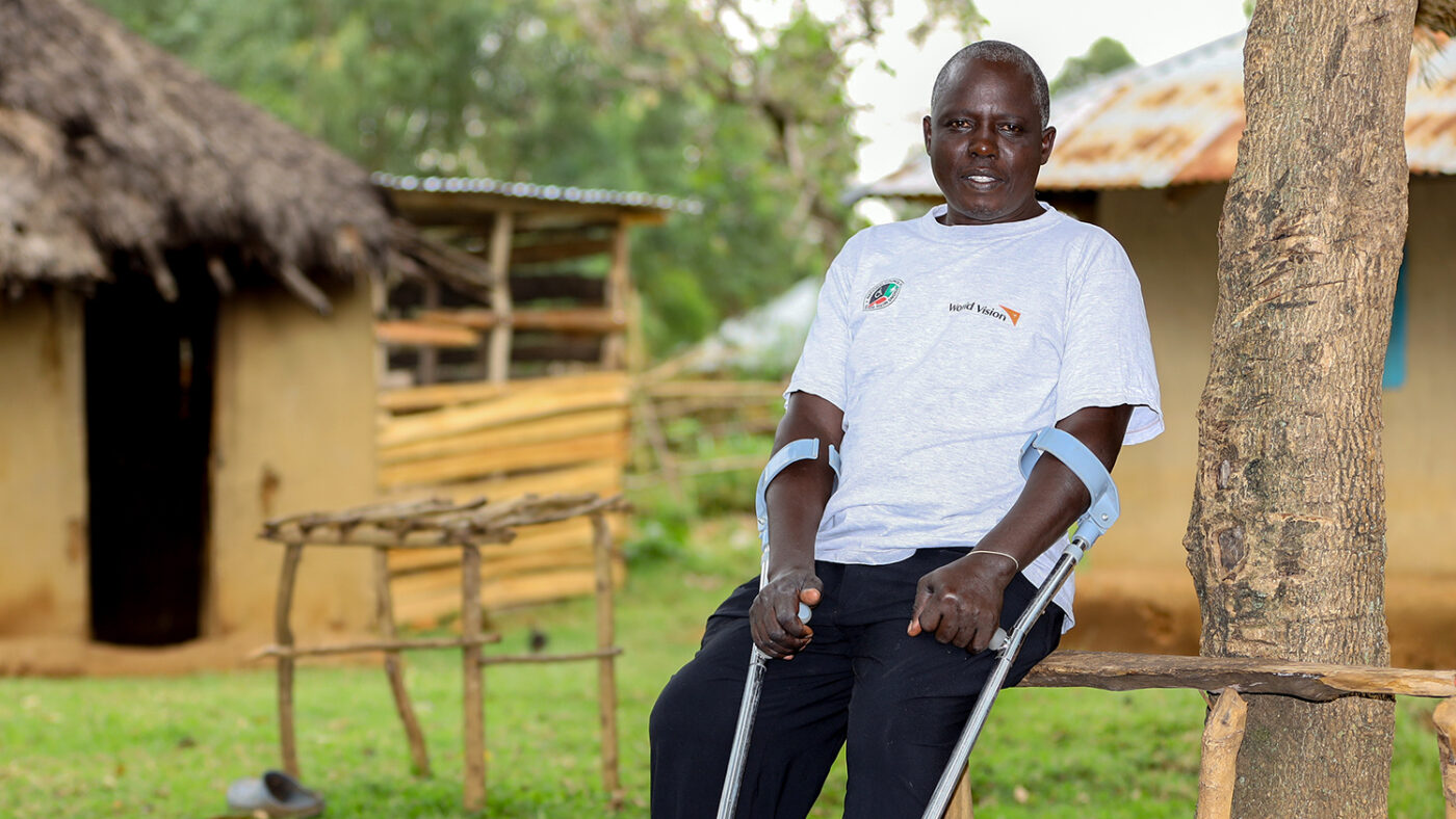 Jacob Odero Nyatama sitting holding his crutches.