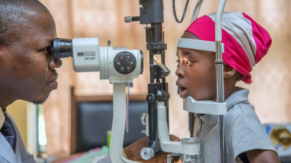 A young girl has her eyes checked by an eye specialist.