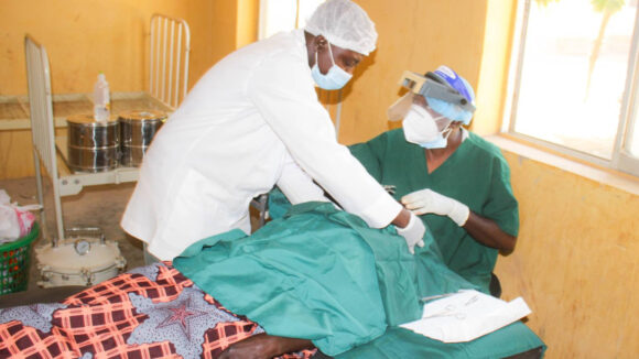 two surgeons work on a patient.