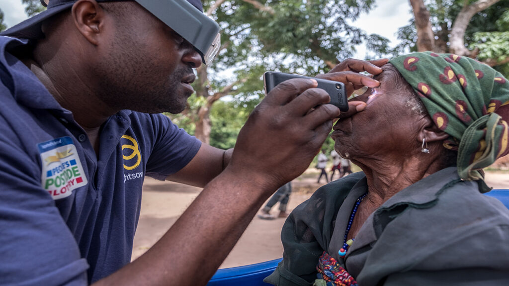 Mai Mai checks a woman's eyes for signs of eye disease.