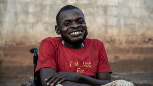 Yakubu, Chair of Association of Persons living with disability, Okene, Kogi, Nigeria, smiles while sitting in his wheelchair.