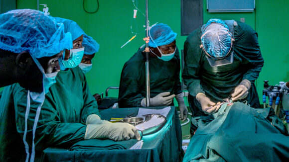 A group of surgeons in a hospital setting performing an operation.
