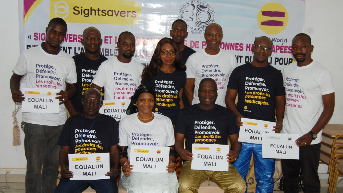 A group of smiling people hold signs that say Equal UN Mali.