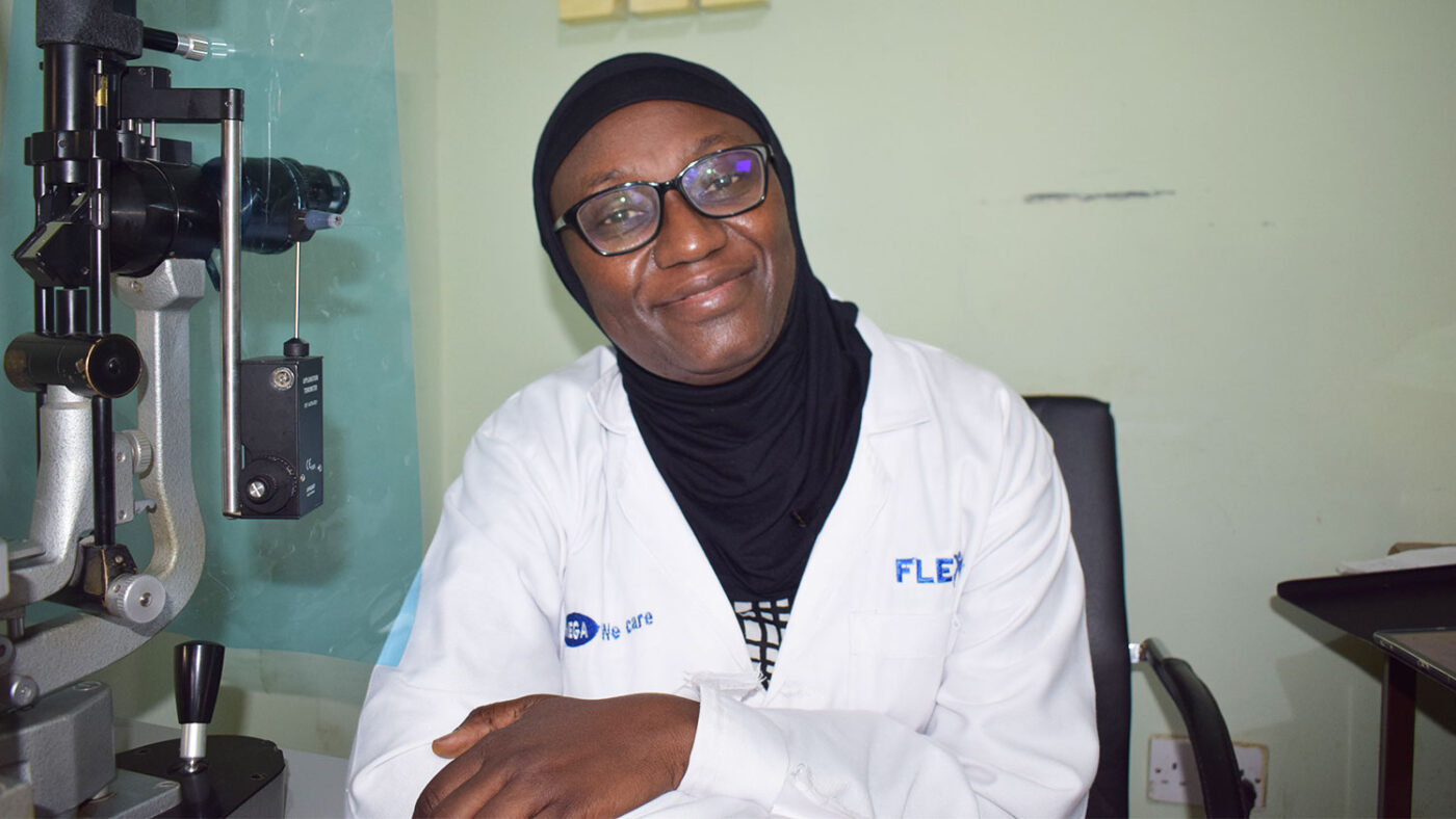 A doctor smiles at the camera in her office.