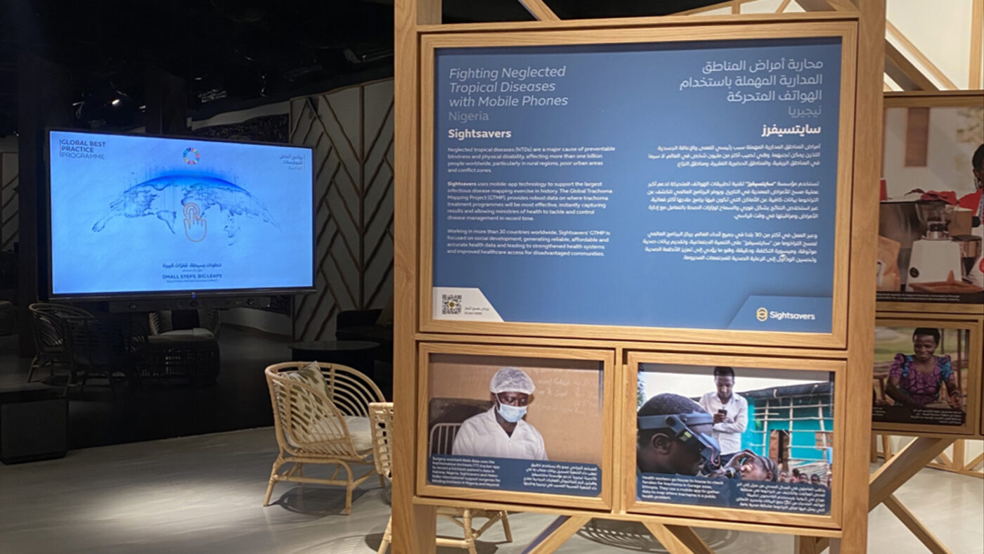 Sightsavers' stand at Dubai Expo, showing a TV screen and a display board with the words Fighting neglected tropical diseases with mobile phones.
