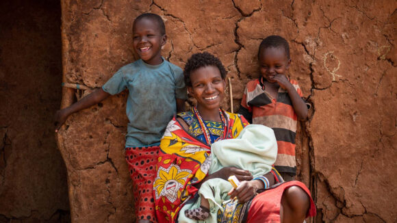 Naomi, Rakonin and Naijara outside a house, smiling.