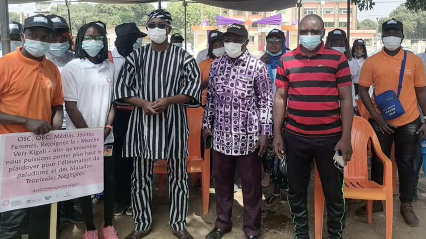 A group of people pose for a photograph with a placard showing support for beating NTDs.