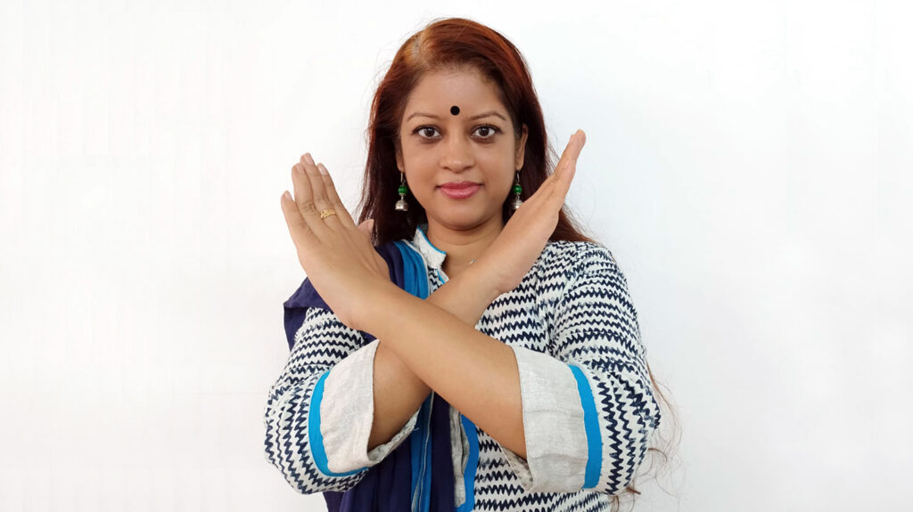 Syeda Asma stands with her arms crossed in front of her chest.