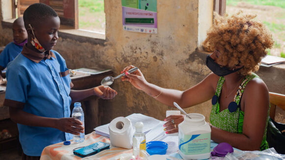 A schoolboy receives medication from a female teacher.