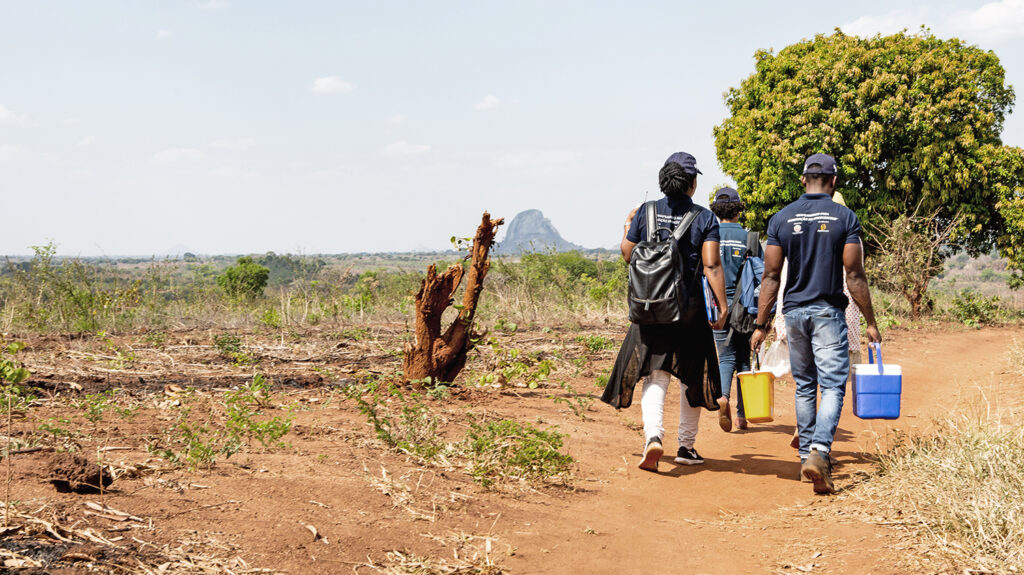 The survey team for the Onchocerciasis Elimination Mapping project in Mozambique walk through the community.