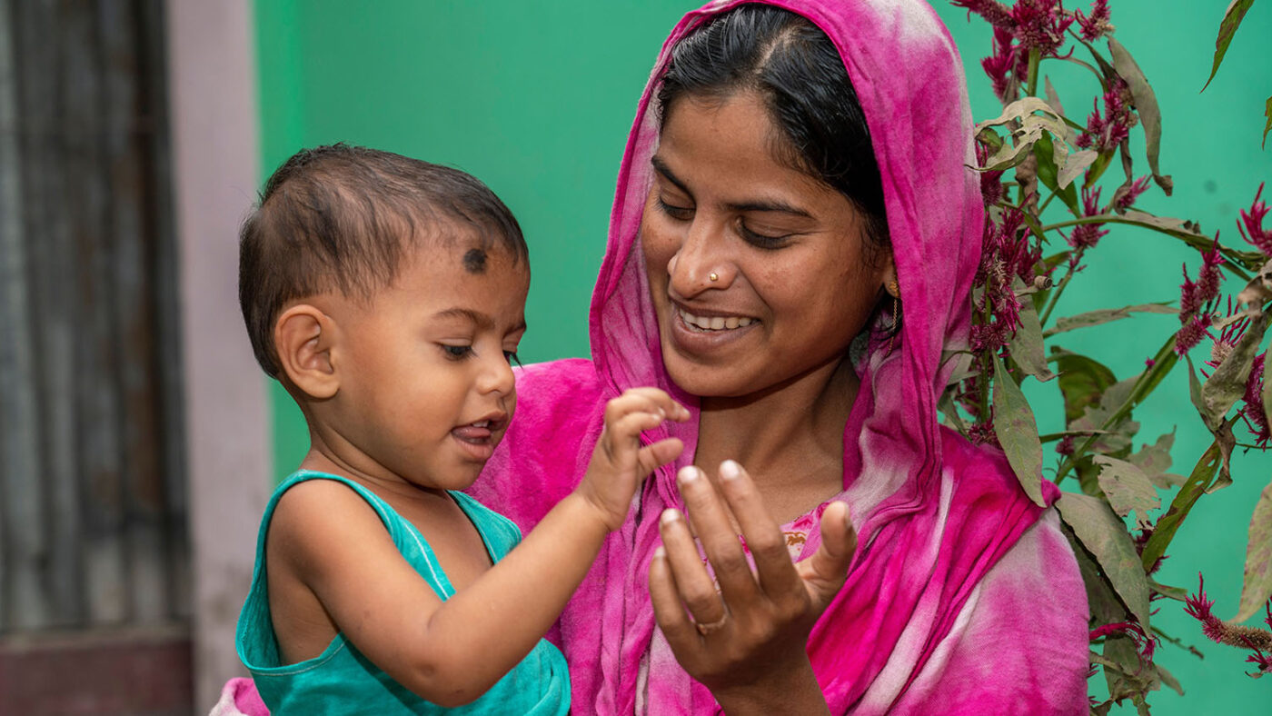 Shamima holds Toha while they play together.