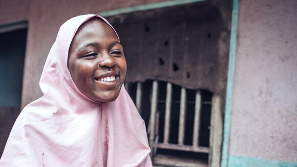 Fatima smiles broadly. She's wearing a pink headscarf.