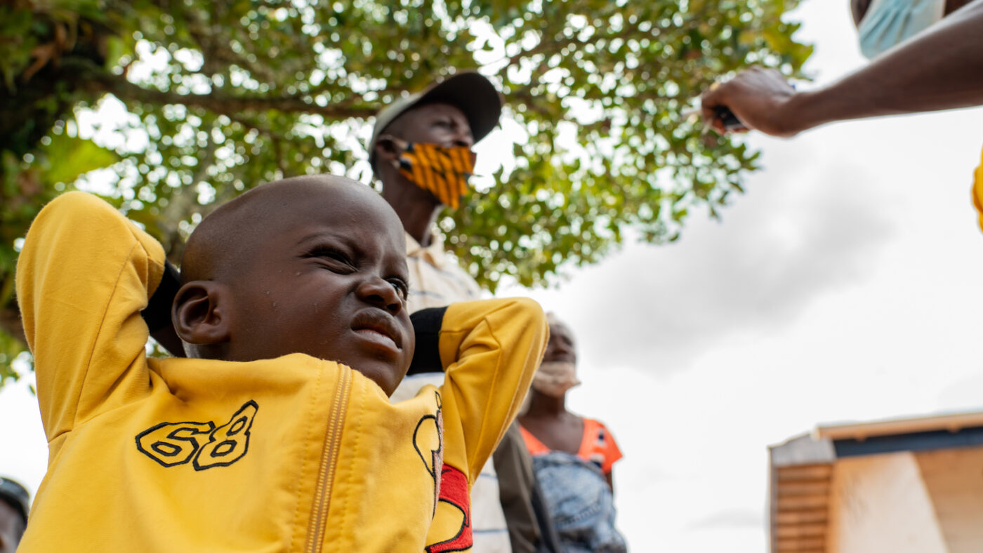 Mehnu stands outside, next to his father. He is squinting his right eye