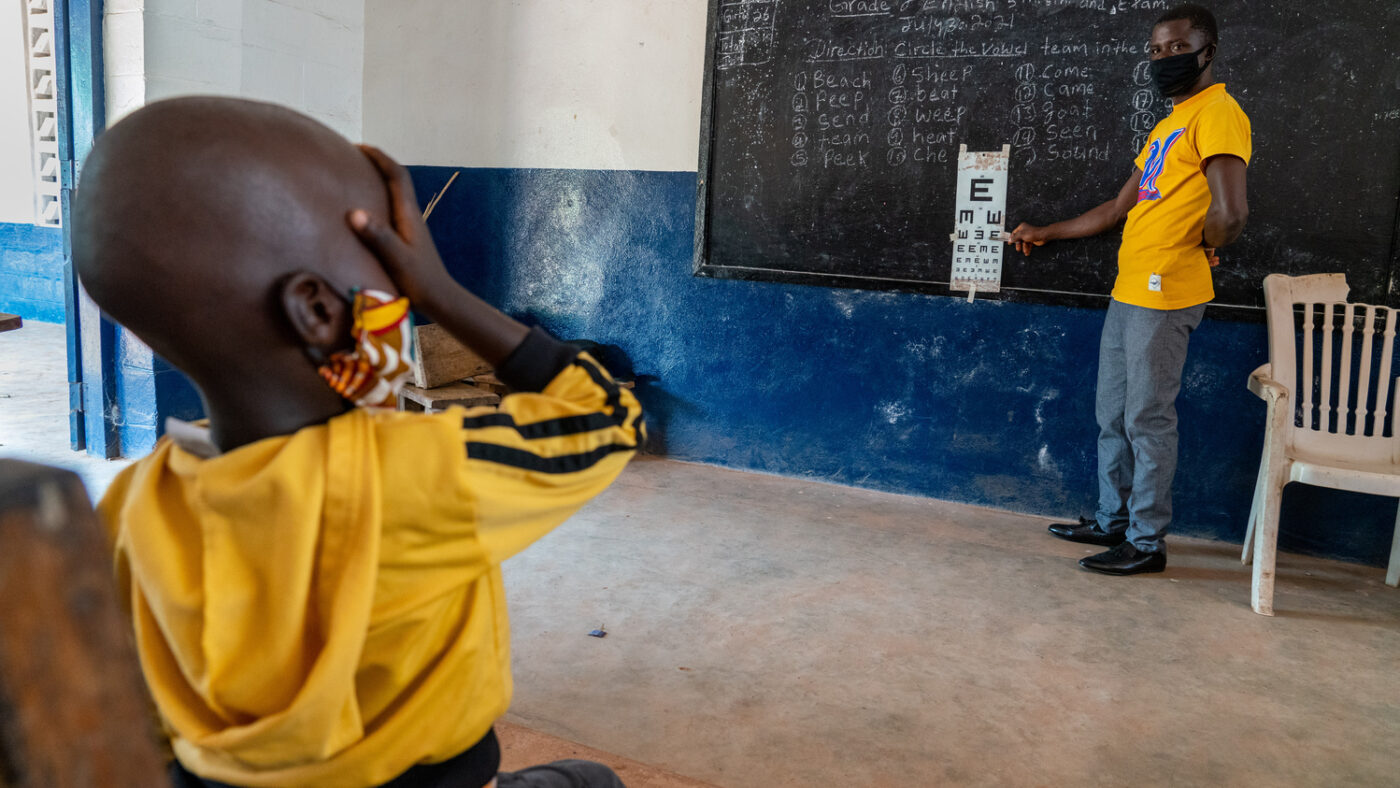 Mehnu covers his right eye during an eye screening