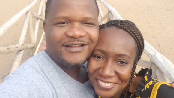 Ophthalmologist Moira with embraces her husband while visiting a lake.