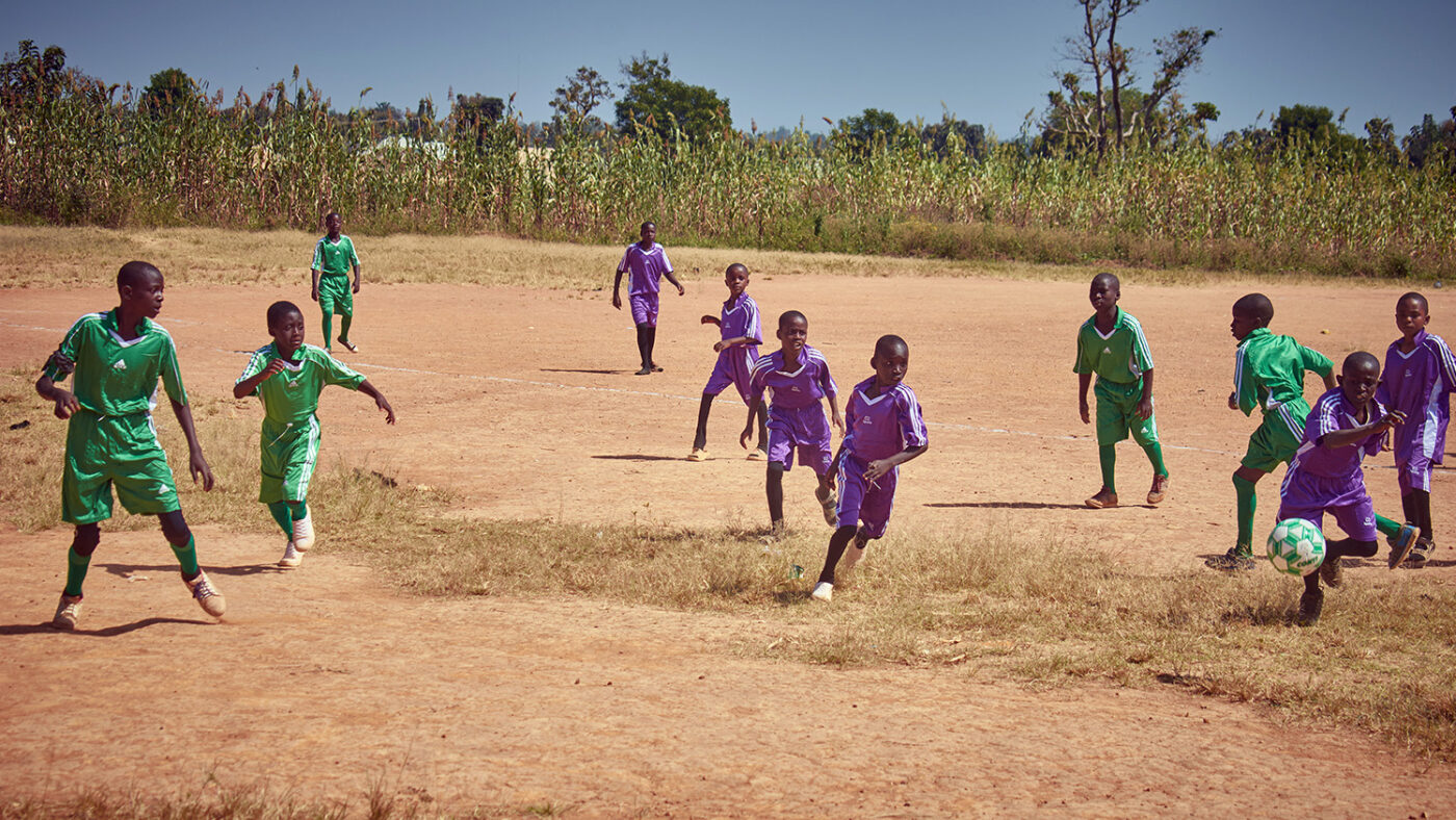 Schoolchildren run around during a game of football.