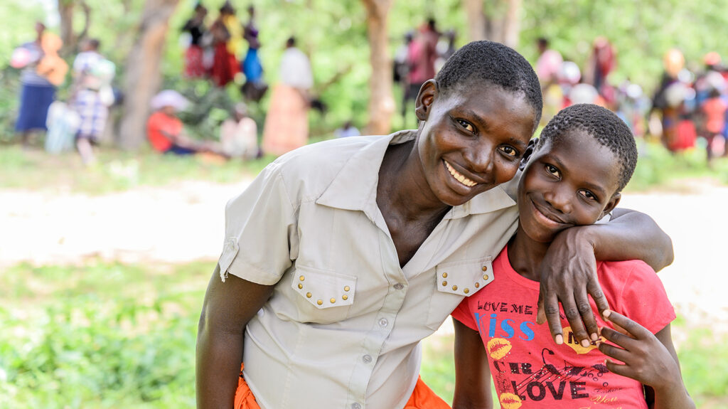 A woman and child in Zimbabwe smile broadly at the camera.