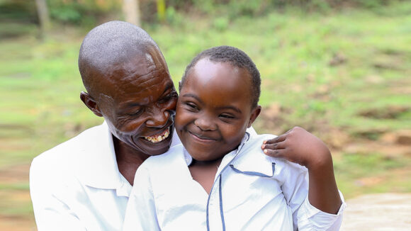 Absalom smiles as he hugs Irene.