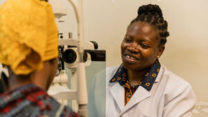 Upendo talks to a patient during an eye test.