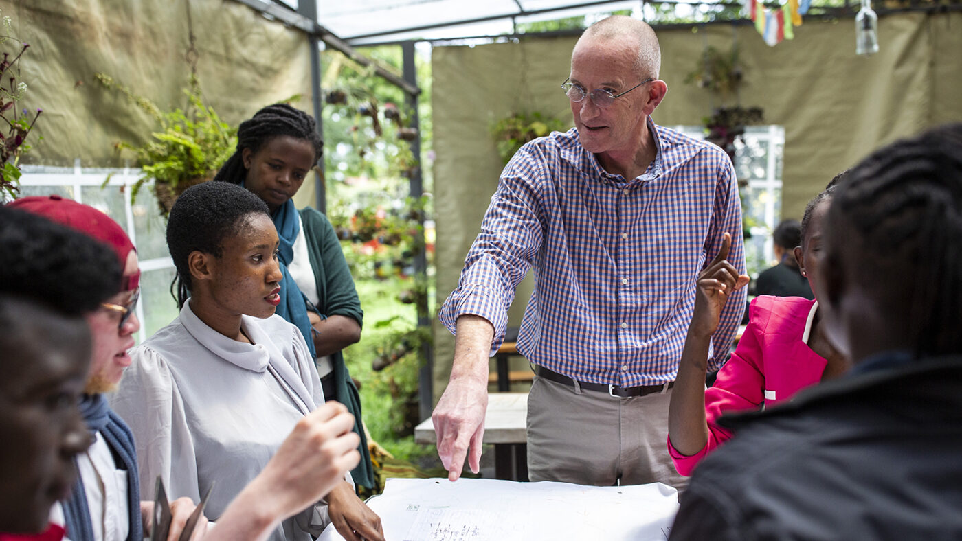 Simon Brown talks to a group of jobseekers with disabilities who are seated around a table.