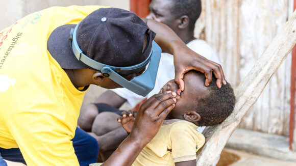 Ndumiso Ndlovu examines a child's eye for trachoma