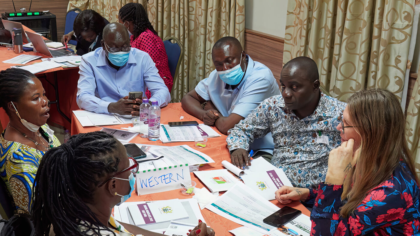 A group of people sit around a table during a training session.