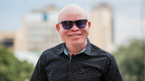 John Chiti smiles while wearing sunglasses.