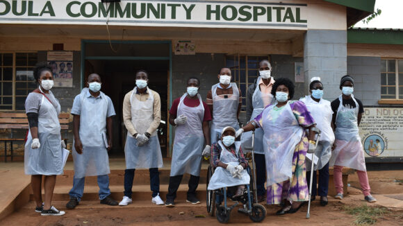 A group of people wearing PPE prepare for an accessibility audit at a hospital in Malawi.