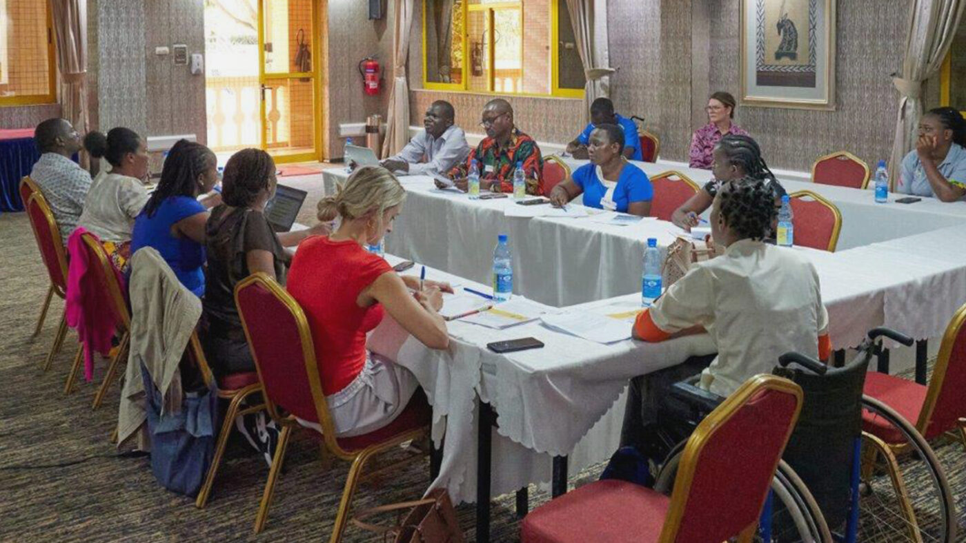 NGO staff sit around a large table during a group discussion on gender-based violence.