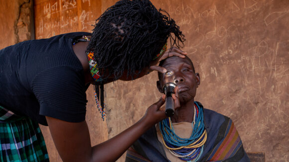 Dr Gladys checks Maria's eyes using a torch.