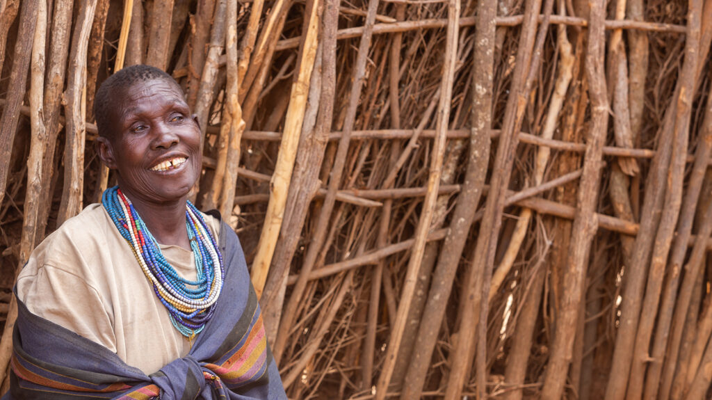 Maria smiles outside her home in Karamoja.