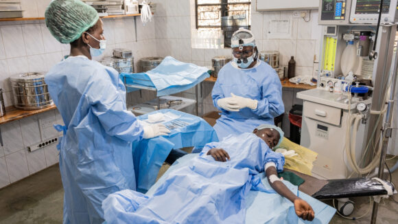 Happy surrounded by surgeons and medical staff during her trichiasis operation.